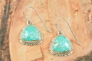 Genuine High Grade Kingman Web Turquoise set in Sterling Silver Earrings. Created by Navajo Artist Larson Lee. Signed by the artist. The Mineral Park Mine, in the Cerbat Mountains 14 miles northwest of Kingman, was first mined by Indians centuries before white man came to the area. It is one of the three sites of prehistoric mining localities in the state of Arizona. Mineral Park was the most extensively worked area by the Indians of the three. S.A. �Chuck� Colbaugh found a cache of stone hammers uncovered in ancient trenches and tunnels, when he had the turquoise mining concession in May of 1962. Ithaca Peak and Turquoise Mine (formally called Aztec Mountain or Aztec Peak) are the most famous of the peaks in the area containing turquoise.
